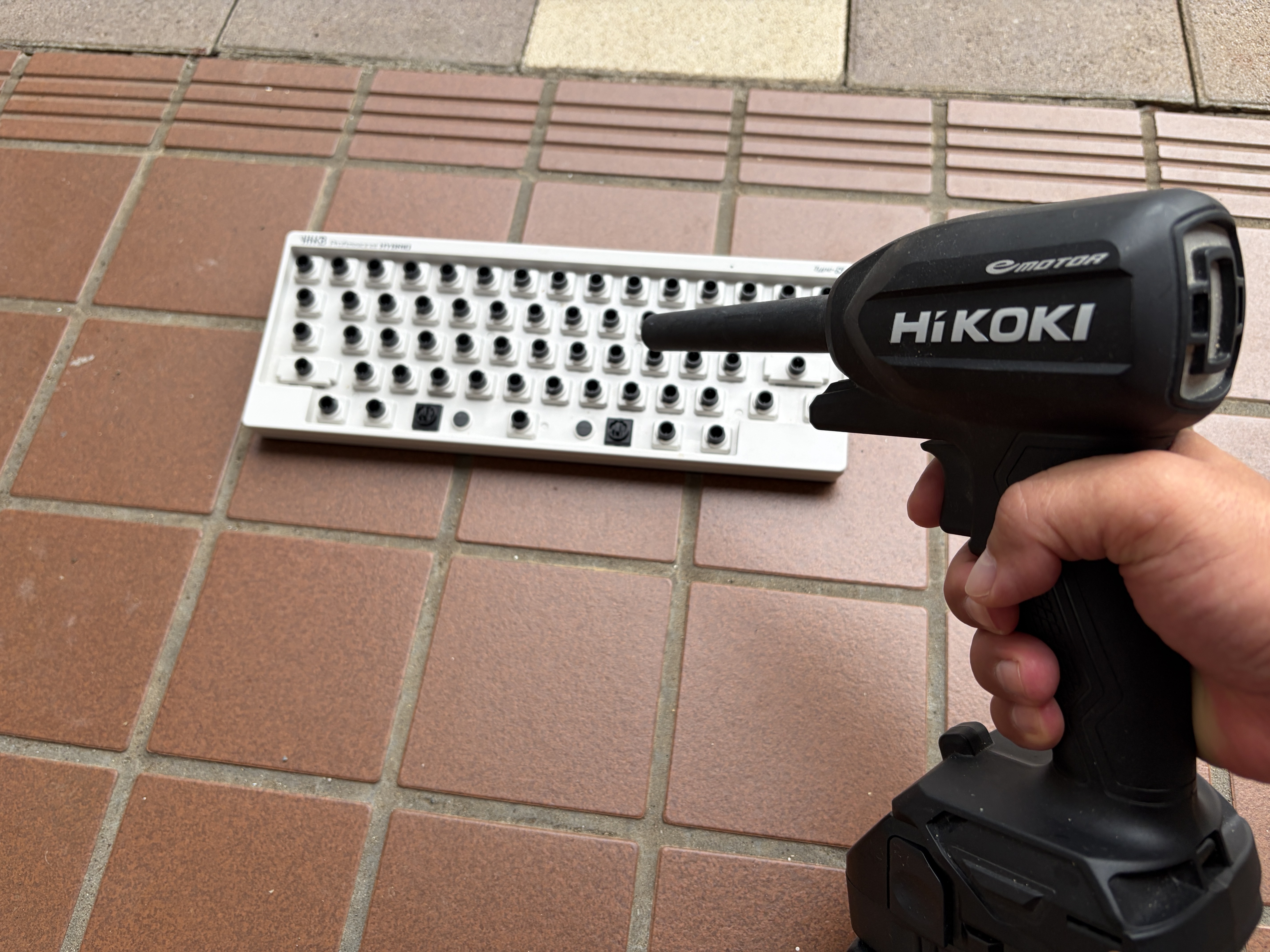 キーキャップをすべて外したHHKBのホコリをエアダスターで吹き飛ばしている様子