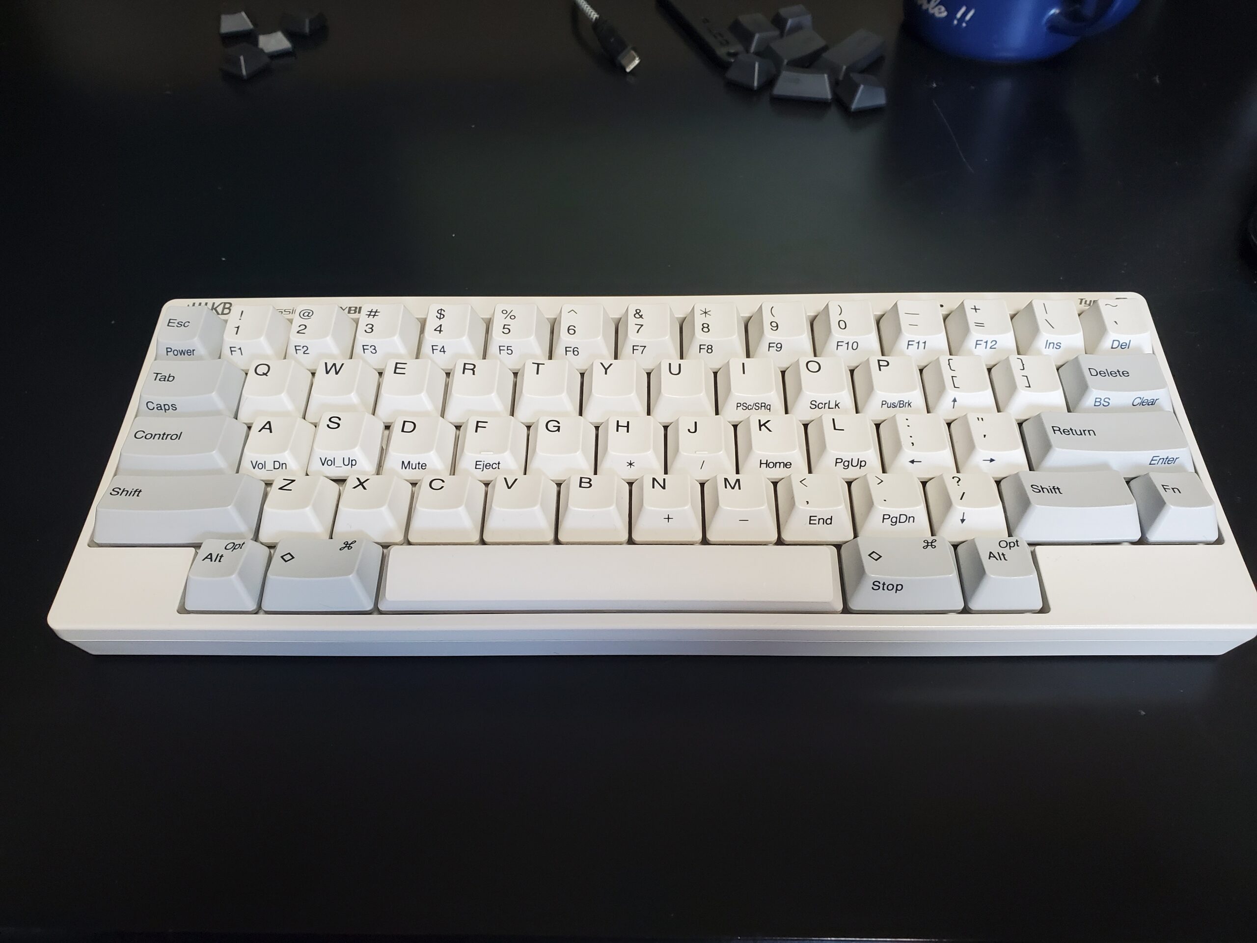 白キーキャップに交換したHHKB Professional HYBRID Type-Sを正面から撮影した写真。奥には取り外した黒キーキャップが並ぶ